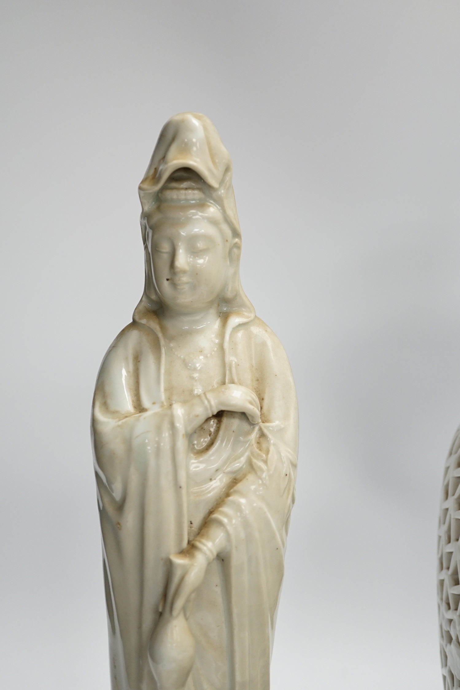 Chinese ceramics comprising blue and white brush washer, a blanc de chine pierced table lamp and figure of Guanyin, largest 42cm high